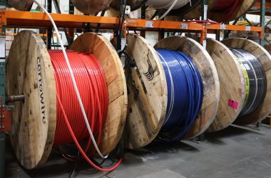 Warehouse wire reels with red, blue, and black electrical cable ready for custom cuts and contractor pickup.